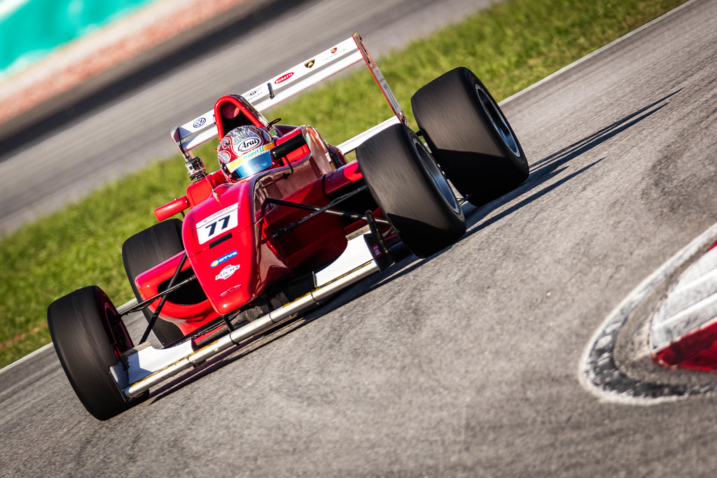 Worawong Komarakul racing a red Meritus.GP single-seater at Sepang